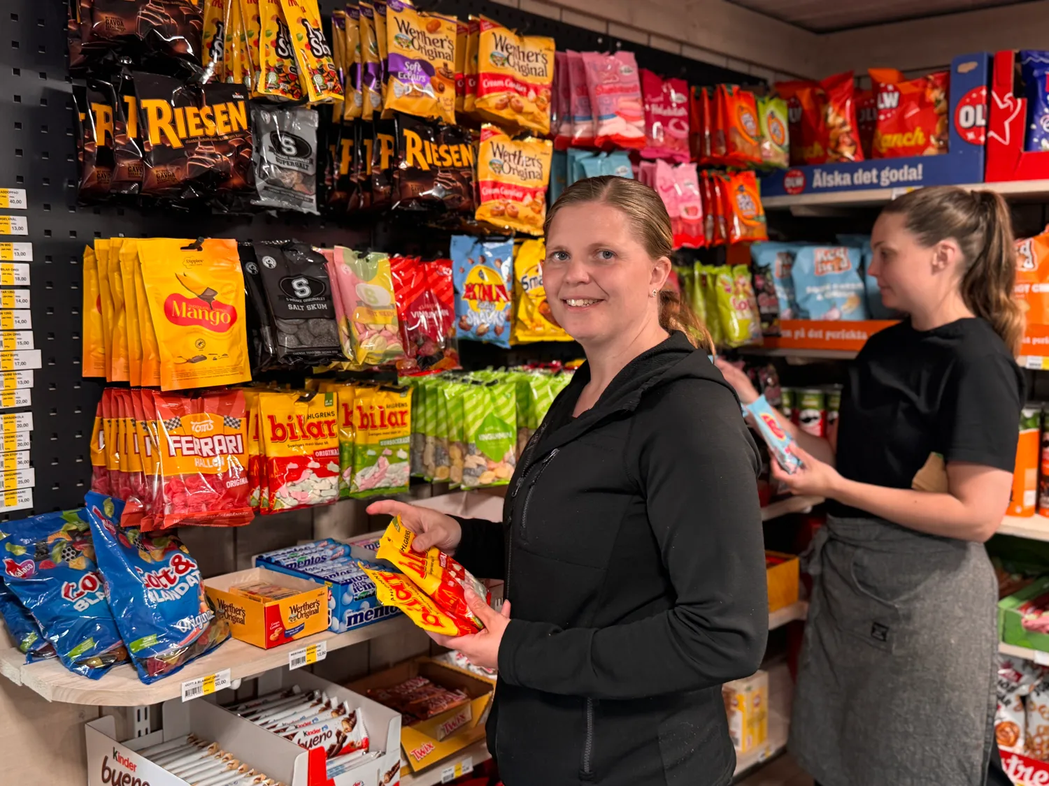Kvinna står vid godiset i en lanthandel.
