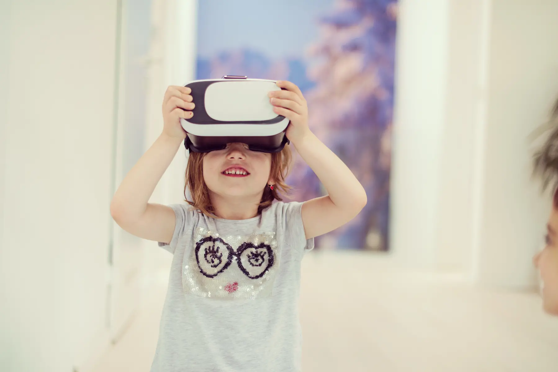 Barn med VR-glasögon som ler