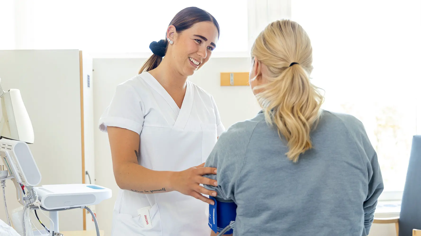 Sjuksköterska tar blodtryck på patient.