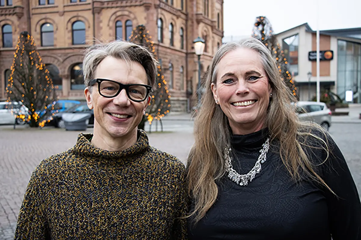 En man och en kvinna står bredvid varandra och ler. 
