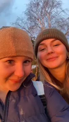 Två tjejer med mössor tar en selfie.
