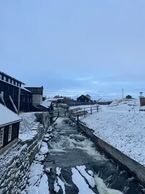 En snötäckt by och en istäckt bäck.